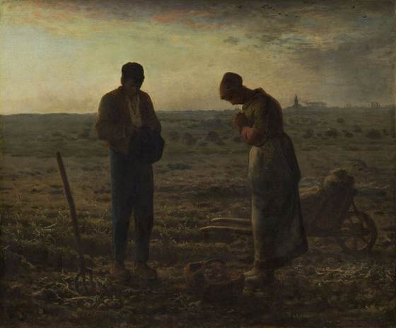 Two field workers stand with heads bowed in prayer at dusk