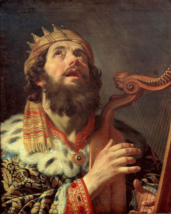 King David, crowned and robed in ermine, looks up as he plays a golden harp