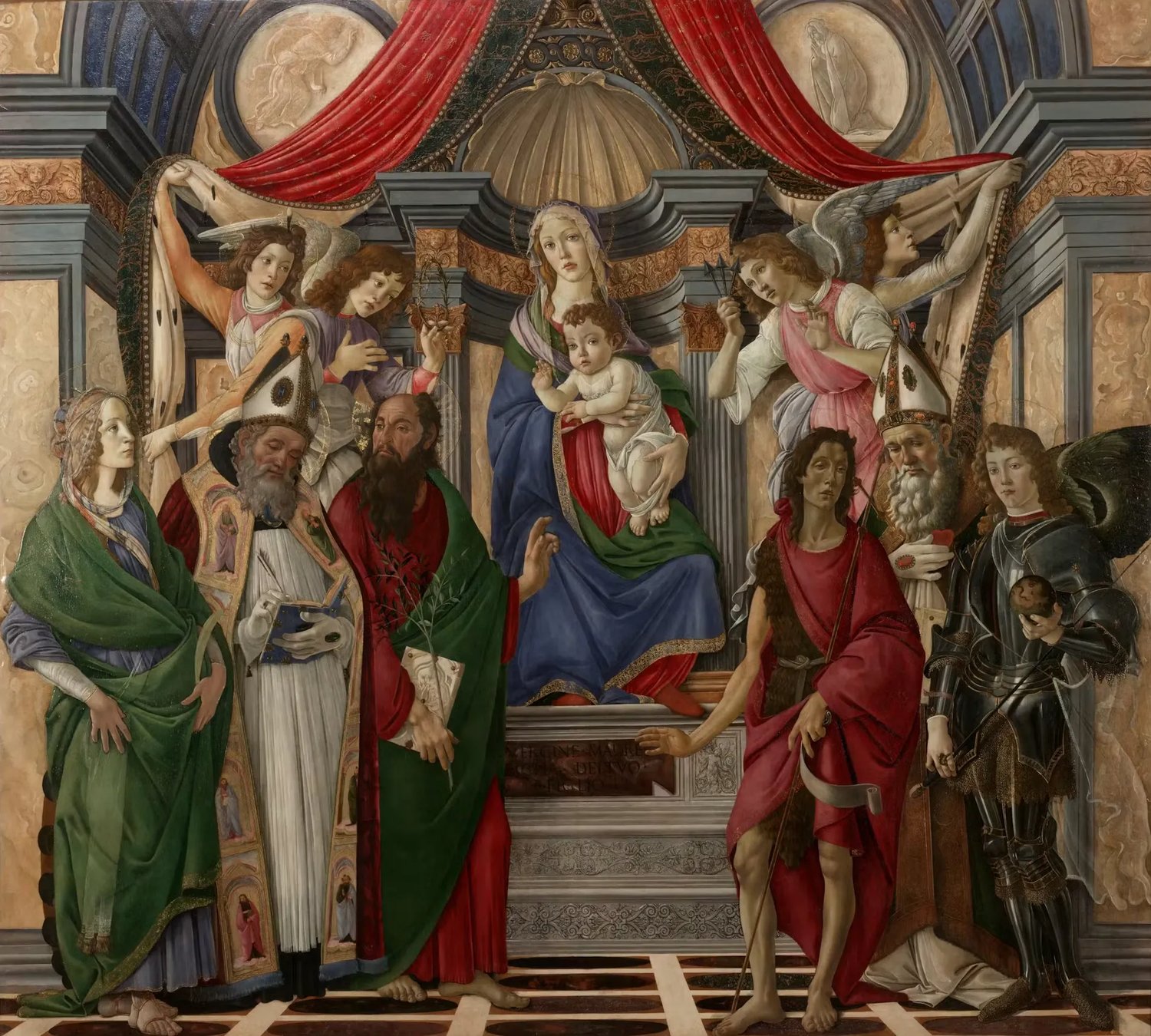 An altarpiece by Botticelli: Mary sits enthroned under a red canopy with the Christ Child on her knee, while four angels draw back the curtains, two of them holding up the crown of thorns and the nails. Six saints stand below. From the left: Catherine in green, Augustine in a bishop's mitre, then Barnabas, a bearded man in a red robe and a green cloak, holding an olive branch and a book. On the right are John the Baptist in red, Ignatius in a mitre, and the archangel Michael in armour.