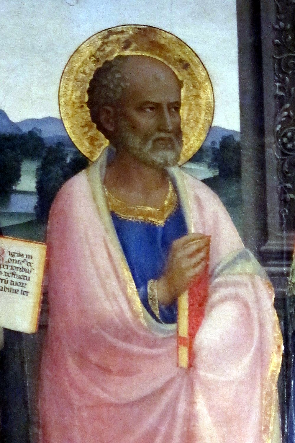 A detail of an altarpiece by Fra Angelico: Barnabas, a balding man with short grey curls and a white beard, looks to the right inside a gold halo. He wears a pale pink cloak over a deep blue robe with a gold collar, and holds a red book against his chest. Behind him are green hills and a pale sky, and at the left edge a page of an open book.