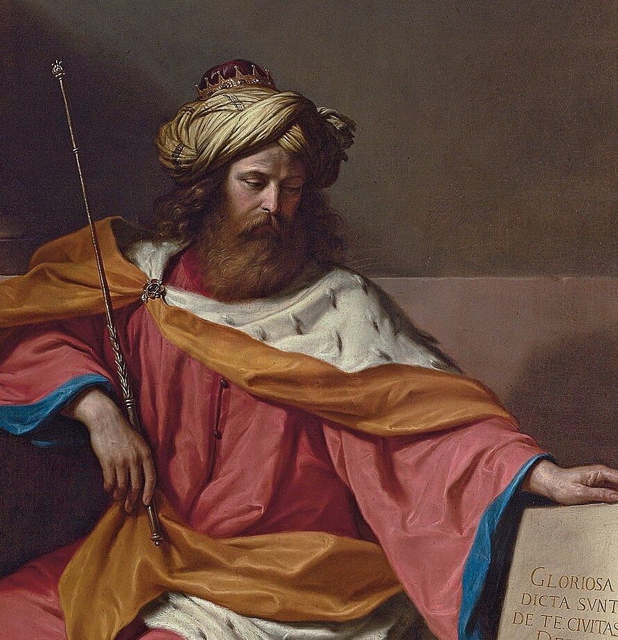 A painting, in detail: David, a bearded king in a gold-and-white turban with a small crown, sits in a rose-red robe with an ermine collar and a golden sash. He holds a long sceptre and rests his hand on a stone tablet carved with Latin words.
