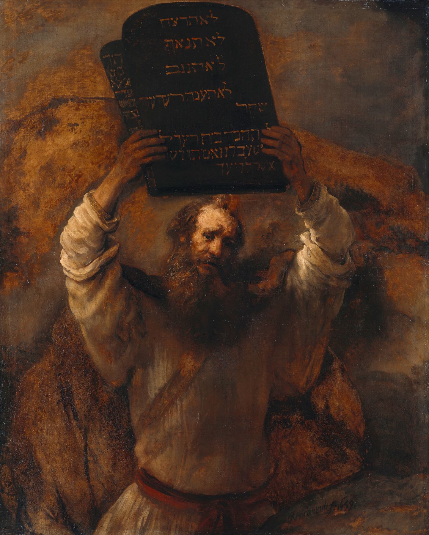 A painting by Rembrandt: Moses, a bearded man with thick grey-brown hair, holds the two stone tablets of the Law high above his head with both arms. The dark tablets are cut with Hebrew letters. He wears a pale robe with a red sash, and his face is grave and sorrowful. Behind him is the dark rock of the mountain.