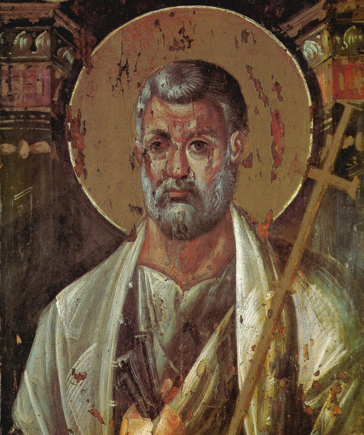 A worn icon on wood: Peter, grey-haired with a short grey beard, gazes straight out before a gold halo. He wears a white cloak, holds keys in his right hand, and carries a cross on a long staff over his shoulder.
