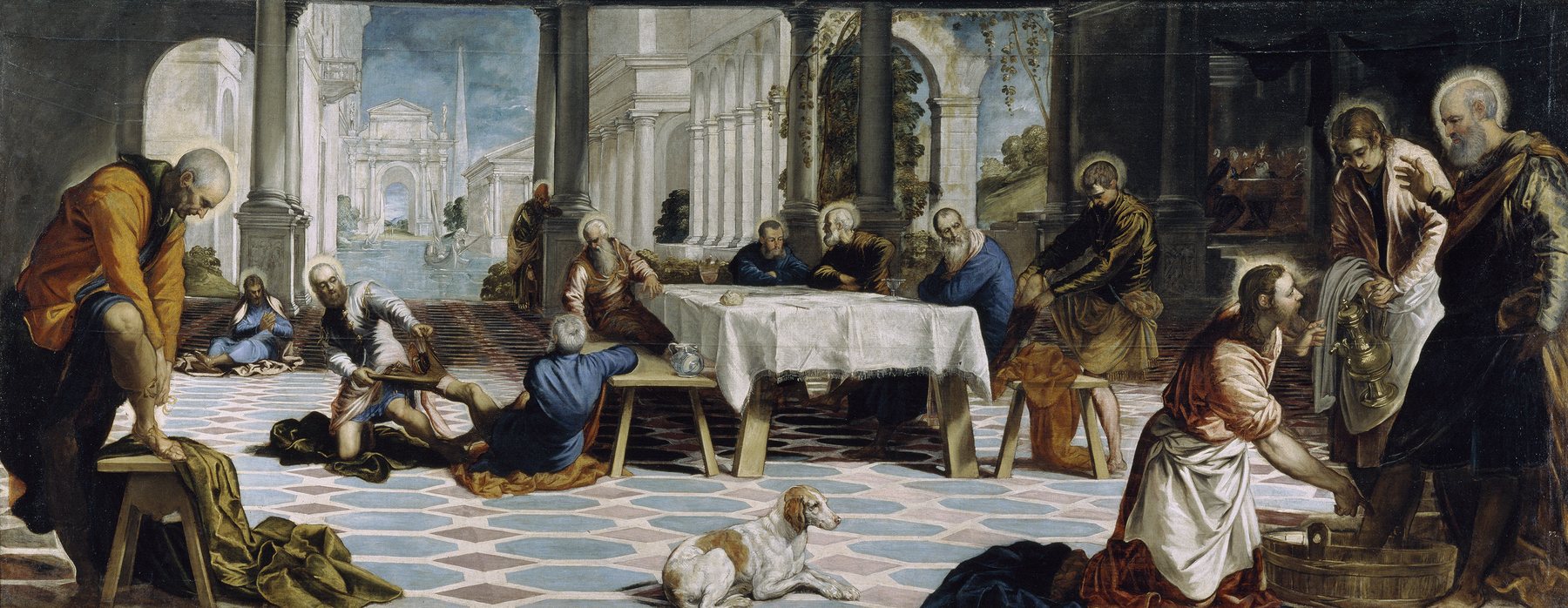 Tintoretto’s painting of Christ kneeling at a basin to wash Peter’s feet while the disciples take off their shoes across a wide tiled hall