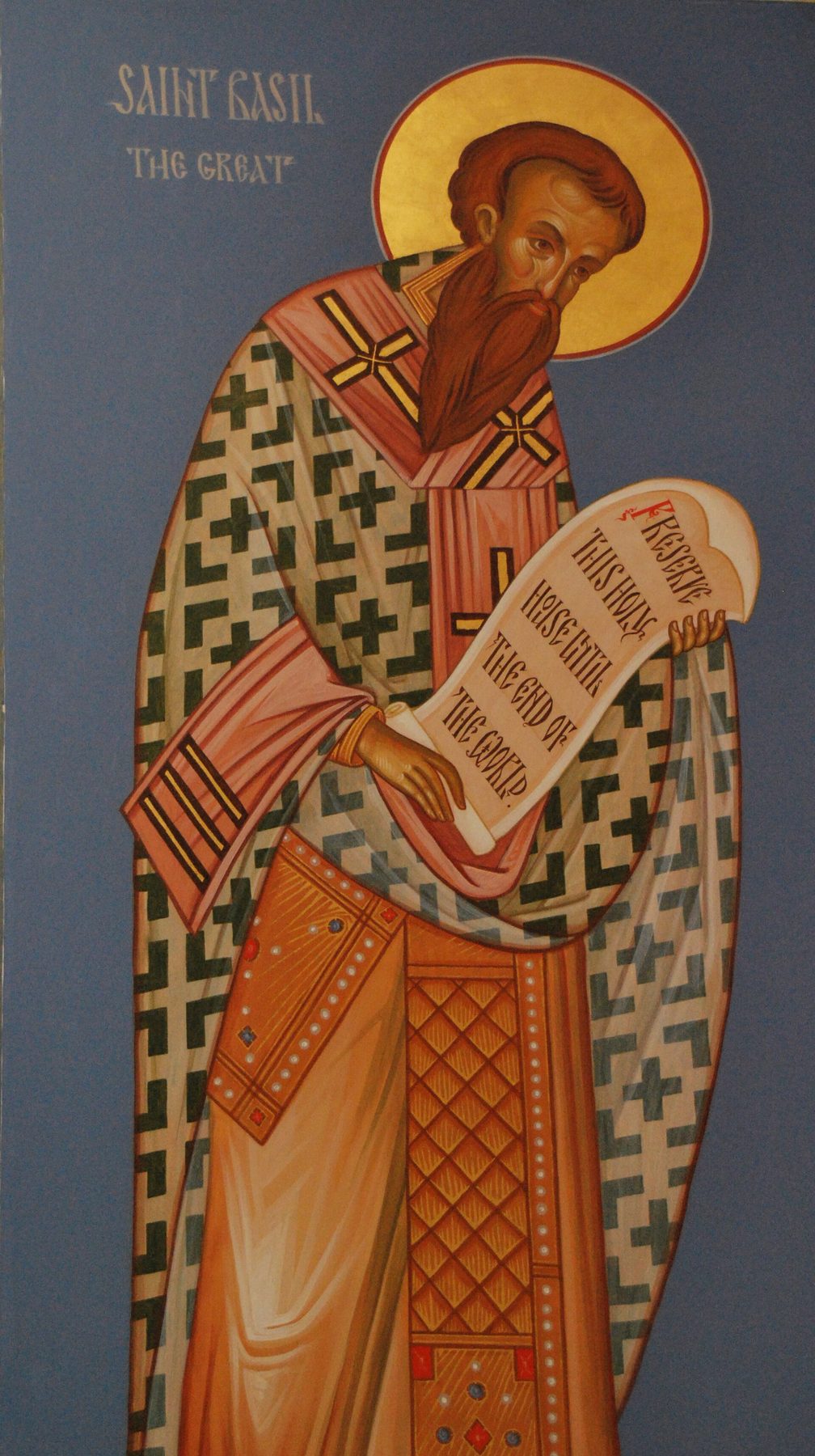 An icon of Saint Basil the Great, lettered in English: a bishop with a dark beard and a gold halo, in a white robe patterned with black crosses over an orange vestment, holds open a scroll