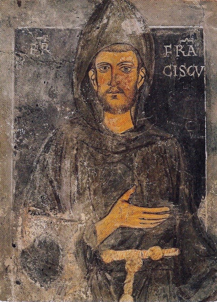 A faded wall painting of a thin young friar in a grey hooded habit tied with a knotted cord, with dark eyes and a short beard, one hand on his chest. He has no halo, and the letters FR FRANCISCU stand beside his head