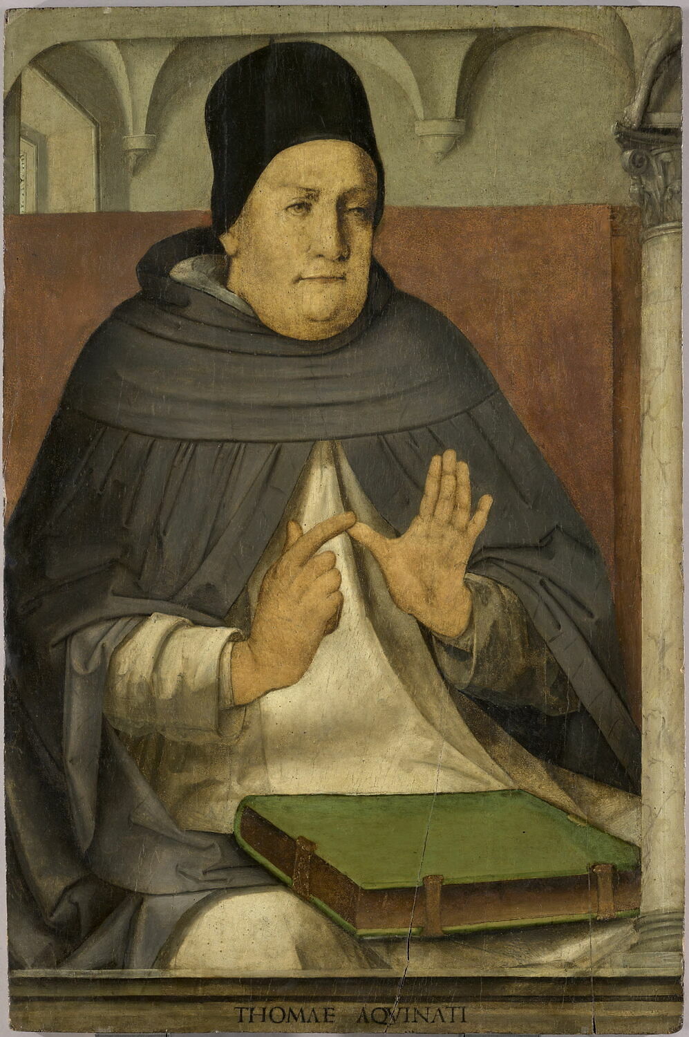 A painting: Thomas Aquinas, a stout friar in a black cap and grey hood, sits in a high wooden chair with a green book before him, raising both hands as if making a point